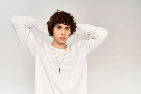Young stylish man in plain attire on serene white backdrop. — Stock Photo