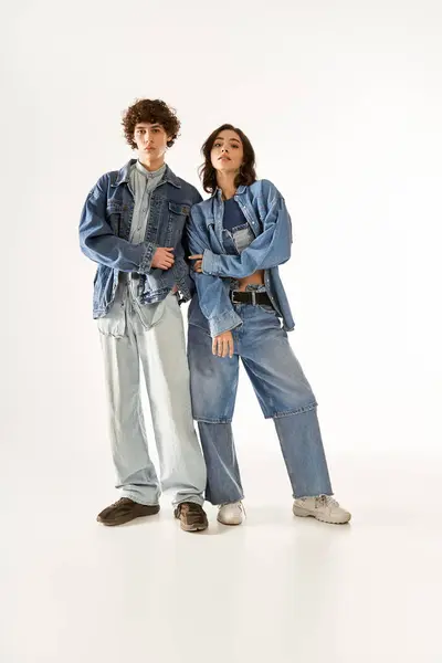 Ein junges Paar präsentiert trendige Jeans-Outfits, die Liebe und Stil in einem zeitgenössischen Raum ausstrahlen. — Stockfoto