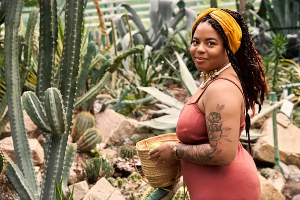 A joyful African American woman with braids enjoys her time surrounded by lush greenery. — Stock Photo
