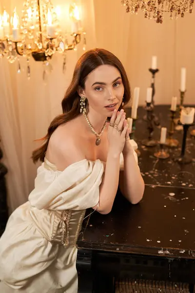 A young woman in a vintage dress poses by candlelight, radiating joy. — Stock Photo