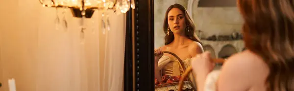 Una giovane donna graziosa si ammira in uno specchio vintage con una luce soffusa intorno, striscione — Foto stock