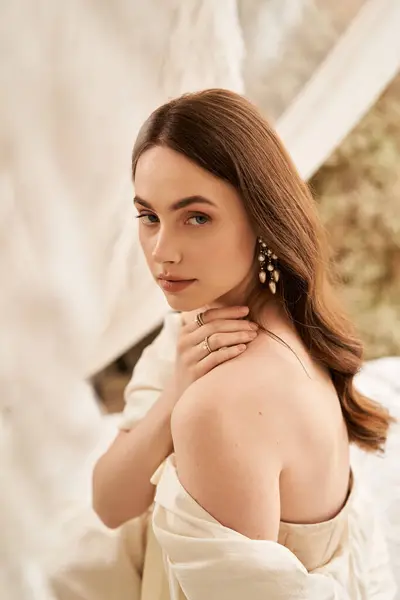 A stylish young woman reflects while wearing a vintage dress amidst soft textures. — Stock Photo