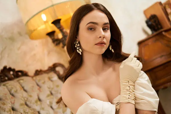 Dressed in an exquisite vintage gown, a young woman exudes elegance in an enchanting environment. — Stock Photo