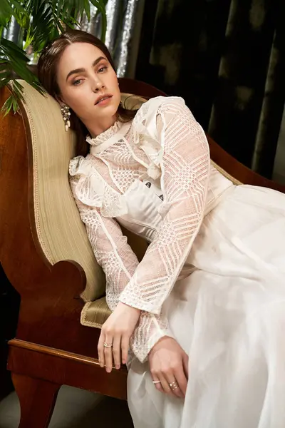 Young woman adorned in a delicate vintage dress lounges gracefully, exuding elegance and beauty. — Stock Photo