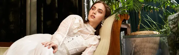 A graceful young woman in a vintage dress relaxes beautifully among the greenery, banner — Stock Photo