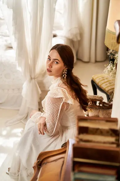 A beautiful young woman sits gracefully in a vintage-inspired room, radiating elegance. — Stock Photo