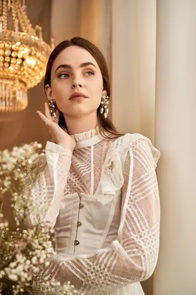 A beautiful young woman stands poised, wearing an elegant vintage dress adorned with delicate lace. — Stock Photo