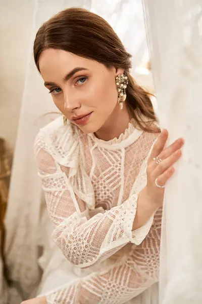 A beautiful young woman poses gracefully in her elegant vintage dress, showcasing her charm. — Stock Photo