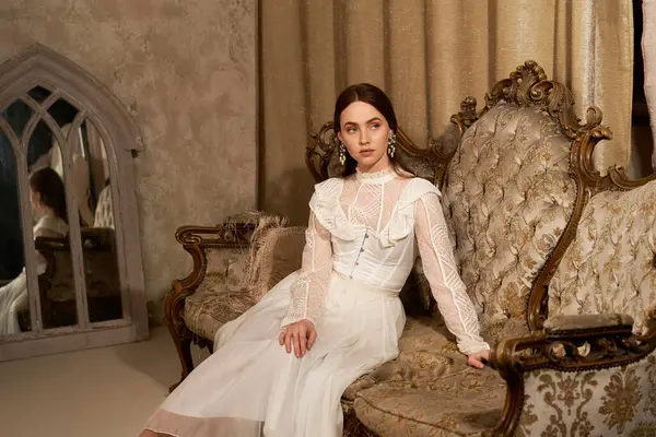 Uma jovem mulher em um vestido vintage relaxa elegantemente em um sofá clássico, exalando charme em um espaço acolhedor. — Fotografia de Stock