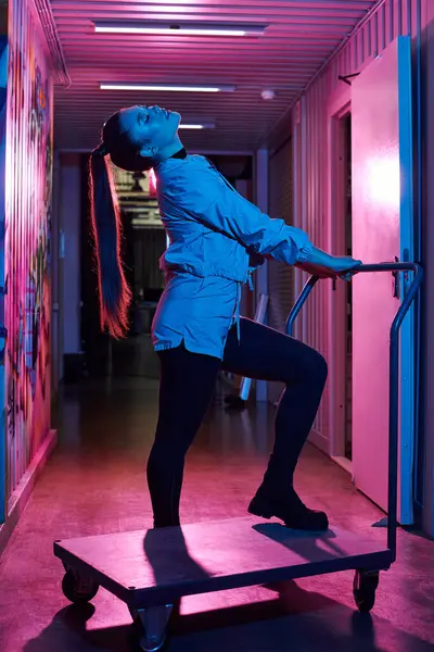 Une femme élégante se tient avec confiance sur un chariot dans un couloir lumineux. — Photo de stock