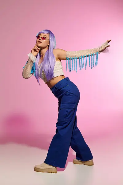 Stylish woman poses with confidence, showcasing her bold outfit and playful accessories in a studio. — Stock Photo