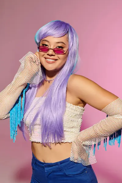 A stylish woman flaunts colorful hair and chic accessories in a fun pose. — Stock Photo