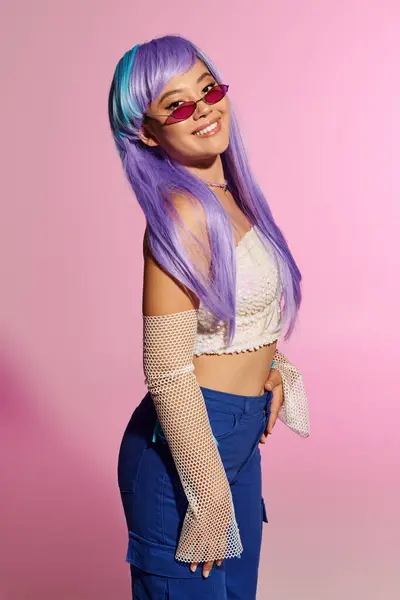 A beautiful woman showcases her trendy outfit and colorful hair while smiling confidently. — Stock Photo
