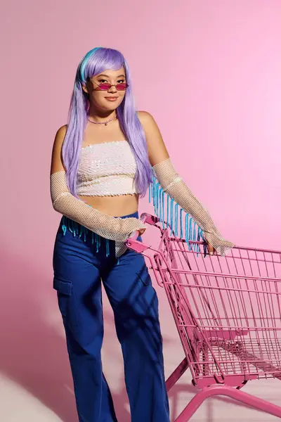 Una mujer segura y elegante muestra su moda única contra un telón de fondo de pastel. - foto de stock