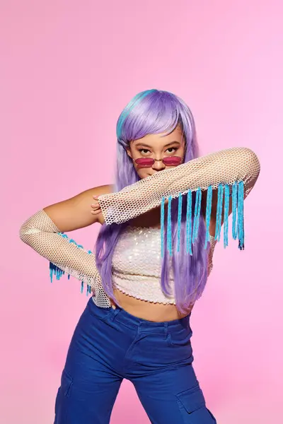 A stylish woman displays her colorful hair and bold accessories while posing. — Stock Photo