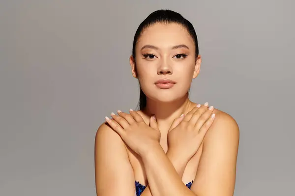 A fashionable woman showcases her beauty with a confident pose against a soft background. — Stock Photo