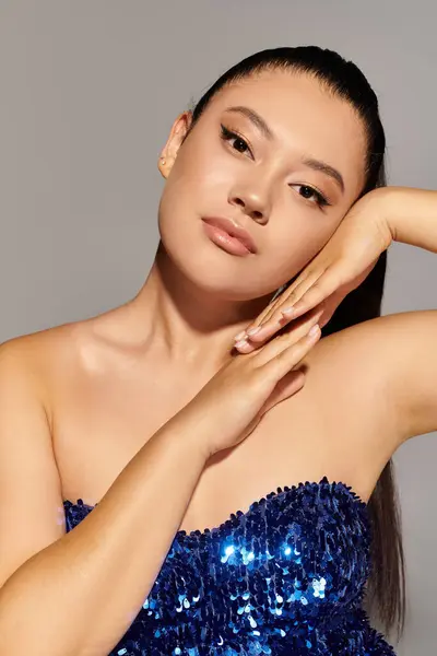 Una mujer hermosa posa elegantemente, vistiendo un traje azul brillante que resalta su elegancia. — Stock Photo