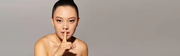 Eine schöne Frau nimmt eine selbstbewusste Pose mit einem Finger an den Lippen ein und ruft Intrigen und Stil hervor. — Stockfoto