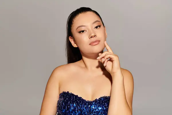 Schöne Frau in glamourösem Outfit posiert vor minimalistischem Hintergrund. — Stockfoto