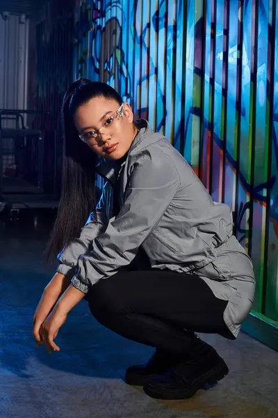 Uma mulher elegante posa confiantemente contra um cenário urbano impressionante, mostrando sua moda. — Fotografia de Stock