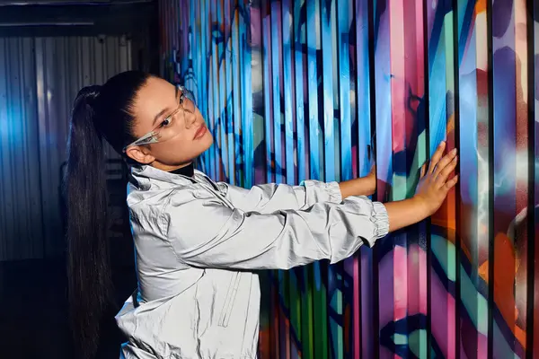 Mit stylischer Brille interagiert die Frau mit lebendiger Straßenkunst in der Stadt. — Stockfoto