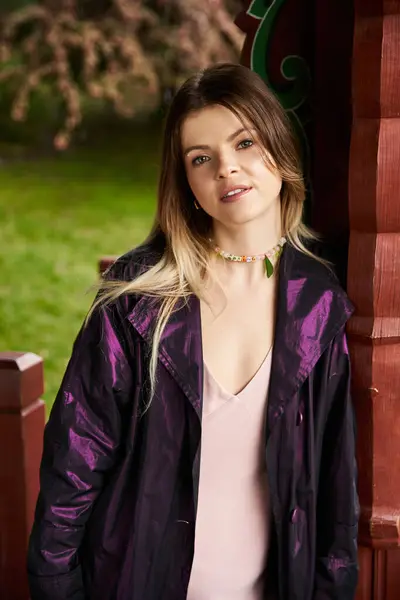 Chaqueta púrpura, collar de cuentas, edificio colorido, día soleado. - foto de stock