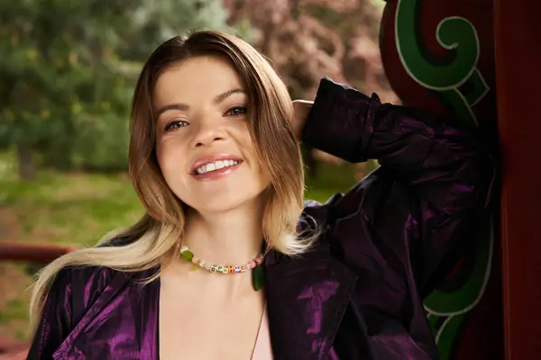 A young woman with a colorful necklace smiles. — Stock Photo
