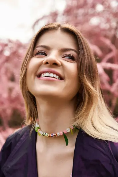 Junge Frau, Frühlingskette, rosa Blüten, freudiger Blick nach oben. — Stockfoto