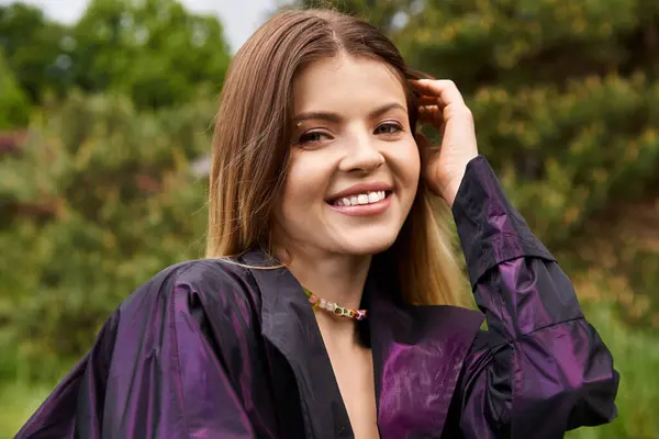 Pretty woman smiles, touches hair outside. Black jacket. — Stock Photo