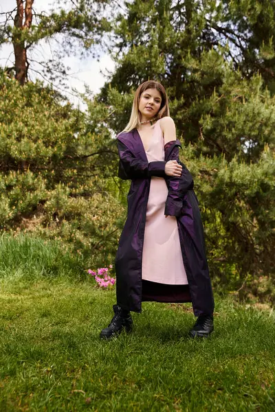 Woman in slip dress and coat, serene in grassy field. — Stock Photo