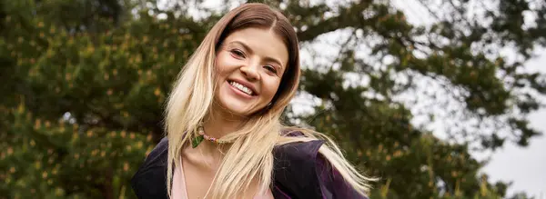 Blonde Frau lächelt im Wald und genießt die Natur. — Stockfoto