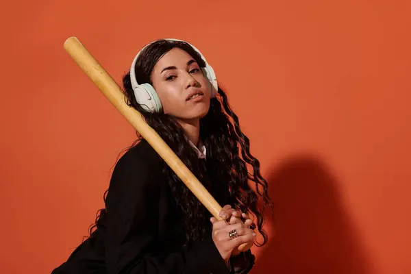 A beautiful young student poses confidently with a bat and headphones, showcasing her unique vibe. — Stock Photo