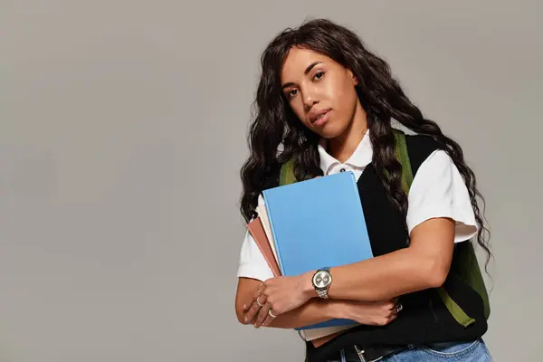Woman exudes beauty and confidence while holding books, showcasing modern student life aesthetics. — Stock Photo