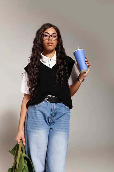 A confident young student showcases her fashion sense while enjoying a refreshing beverage. — Stock Photo
