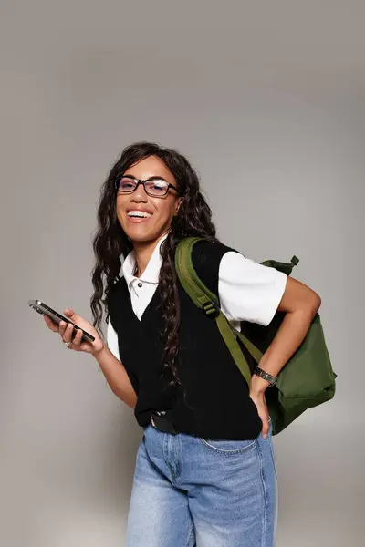 Strahlendes Lächeln strahlt Zuversicht aus, als eine junge Frau mit stylischer Brille ihr Handy betätigt. — Stockfoto