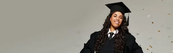 Una joven viga en su gorra de graduación, celebrando su logro en un entorno alegre. - foto de stock