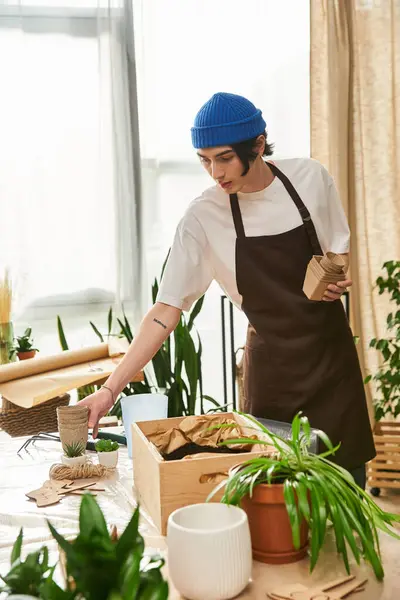 Young man gracefully transplanting plants in a lush studio with natural light streaming in — Stock Photo