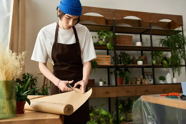 A young man in a cozy studio prepares to transplant plants amidst lush greenery. — Stock Photo