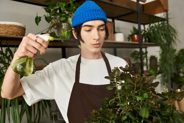 Handsome young man tends to his lush indoor plants, nurturing them with care and attention. — Stock Photo