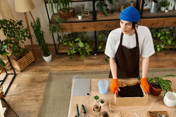 Young man engages in transplanting plants while surrounded by nature inspired decor — Stock Photo