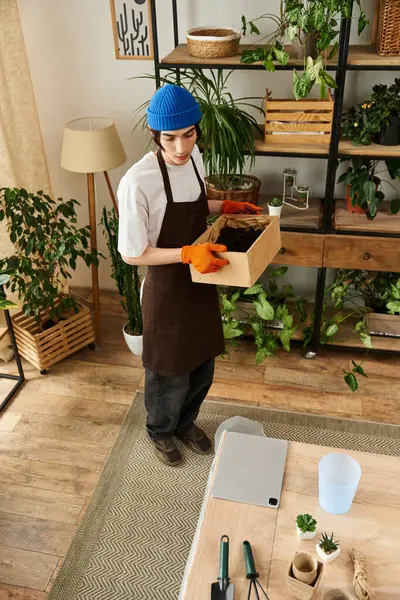 Handsome young man actively transplanting plants in a stylish studio filled with greenery. — Stock Photo