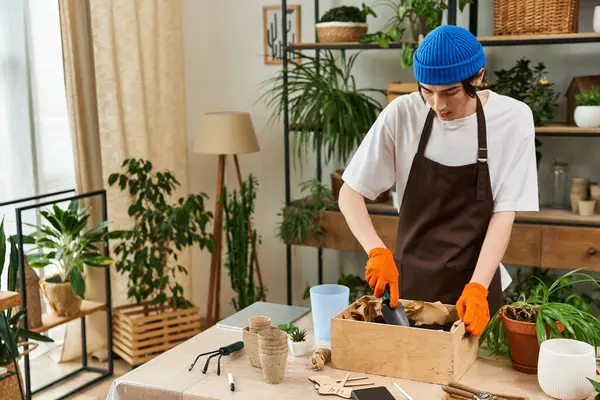 Young man skillfully transplanting plants in a vibrant indoor studio filled with greenery. — Stock Photo