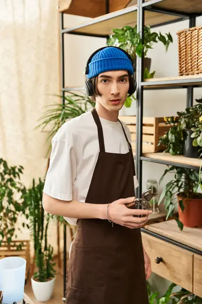 In a bright studio, a young man lovingly transplants plants, showing his passion for gardening. — Stock Photo