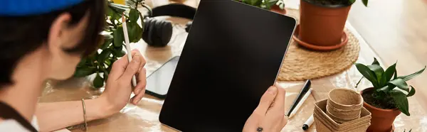 Handsome young man looking at tablet while seated in a vibrant studio setting. — Stock Photo