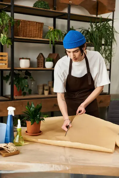 Focused individual preparing to work with plants in a bright, modern studio environment. — Stock Photo