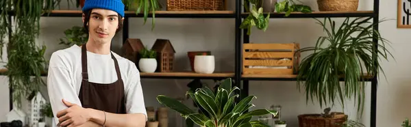 Handsome young man posing with crossed arms near various plants showcasing his gardening skills. — Stock Photo