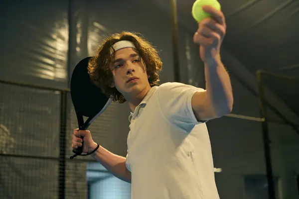 A dedicated young athlete prepares to serve as he enjoages in a competitive game of padel. — стоковое фото