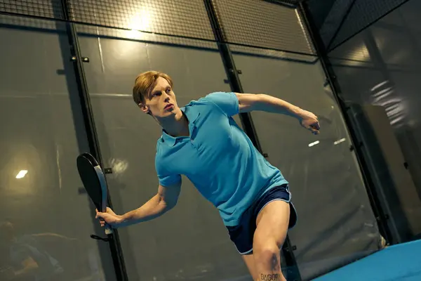 Talented young man engages in an exhilarating game of padel wearing vibrant sportswear. — Stock Photo