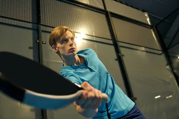 A young man in sportswear plays padel with focus and determination on the court. — Stock Photo