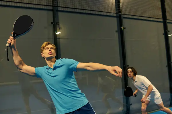 Two young sportsmen engage in an energetic match of padel, displaying skill and teamwork. — Stock Photo